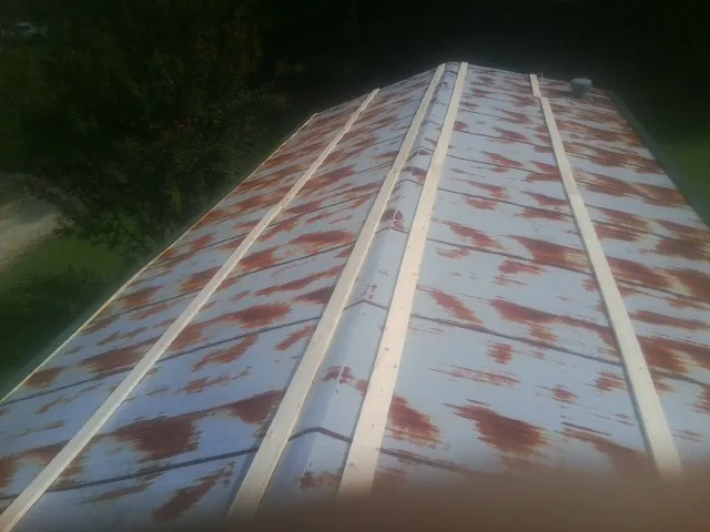 Rusted metal roof panels with new wood purlins before replacement — Storm Damage Roof Repair in Clay by Roofing Brothers