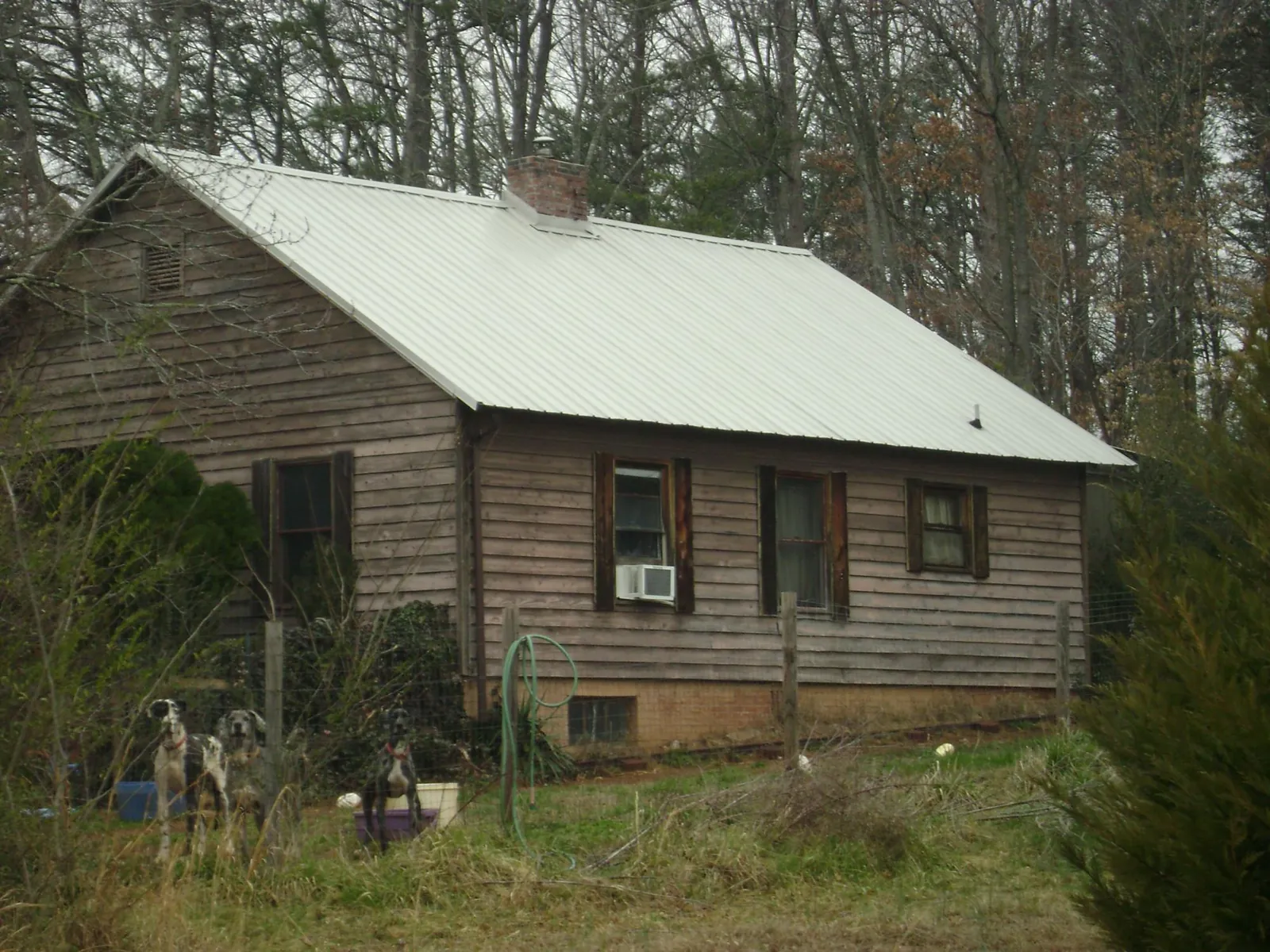 White metal roof on an old wood sided farmhouse, from a Metal Roof Installation job in Clay